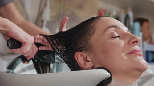 Woman Getting her Hair Wetted and Brushed in Salon