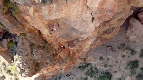 Via ferrata ascension by group of sportsmen drone aerial view of mountain and mountaineers climbing