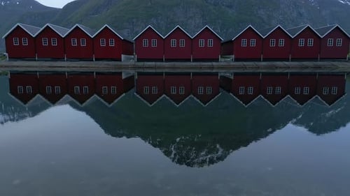 Serene Reflections: Traditional Red Cabins on Norwegian Lake
