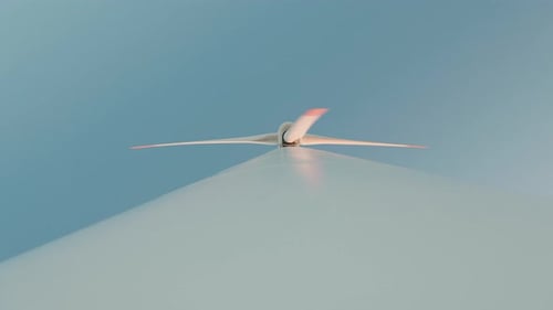 Upward View of a Wind Turbine Rotor in Motion Against a Clear Blue Sky Symbolizing Renewable Energy