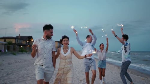 Friends Celebrating with Sparklers on Sandy Beach