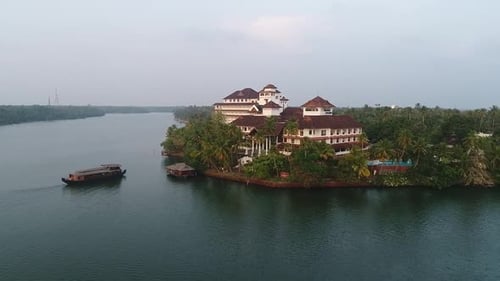 Drone footage of a luxurious hotel with boat and lake side.