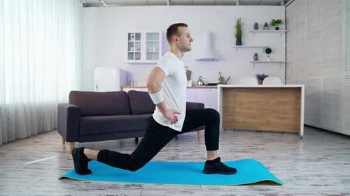 Man Doing Lunges on Yoga Mat Indoors