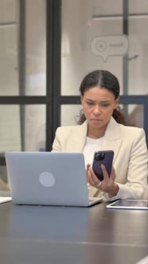Woman Works on Laptop and Phone at Office