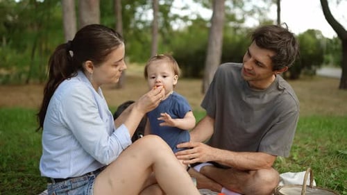 Family Enjoys Picnic in Sunny Park Setting