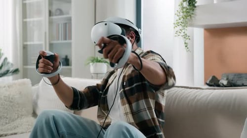 Young Man Plays Video Games in Virtual Reality