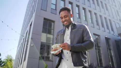 Young Man Counts Money in City, Celebrating