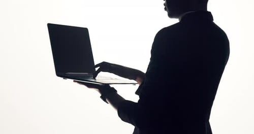 Business person, silhouette or typing with laptop in studio of secret agent on a white background