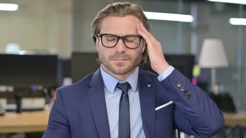 The Portrait of Tired Businessman having Headache in Office