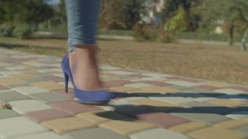 Woman in Blue Heels Walking on Sidewalk