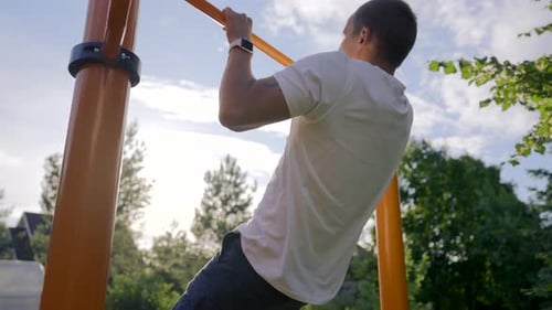 Mature Man Tries to Do Catch Up on Crossbar Jumping in Yard