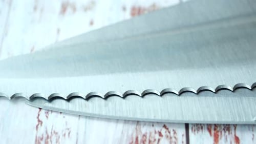 Nahaufnahme eines schwarzen Küchenmessers auf einem Holztisch