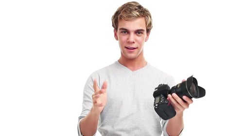 4k video footage of a young male photographer taking videos against a studio background