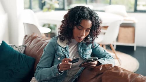 Woman on Couch Using Credit Card and Smartphone