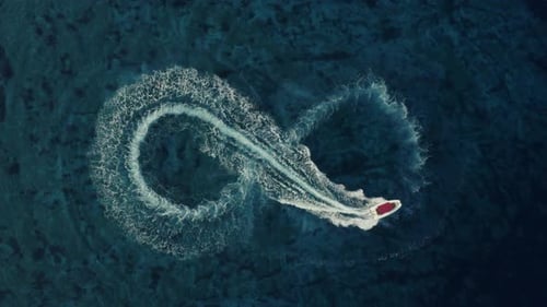 Toma aérea a cámara lenta de una lancha rápida con un techo rojo que forma una forma infinita.