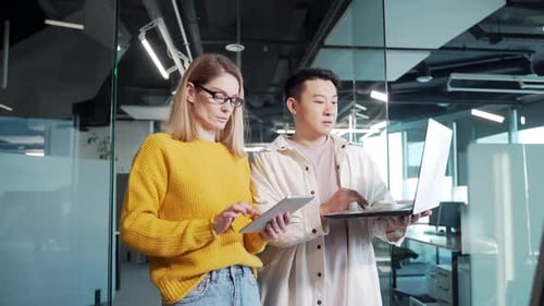 group of creative business people stand in the hallway and discuss. Person workers using laptop
