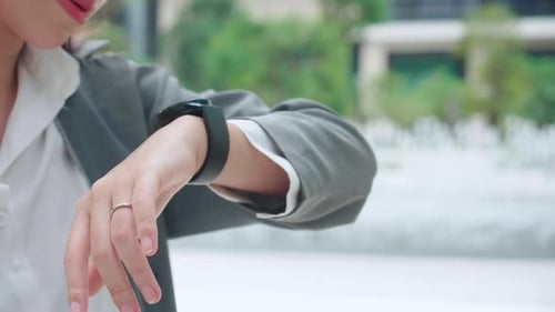 Woman Uses Smartwatch in an Urban Environment