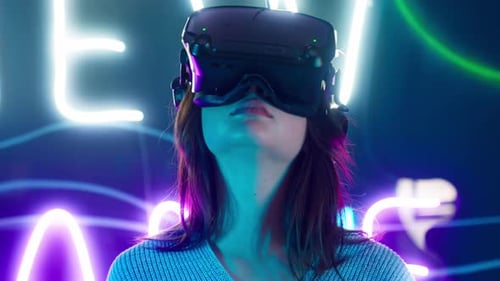 Woman Uses VR Headset in Neon-lit Room
