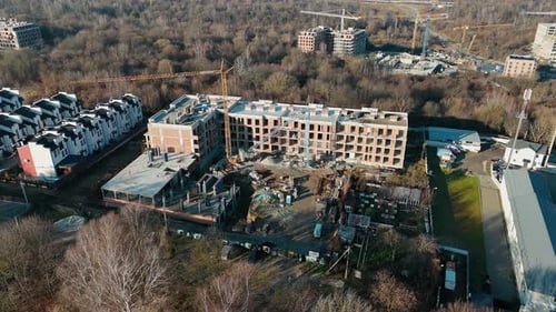 Aerial View of a Residential Construction Site Showing a Building Under Development and Cranes in a