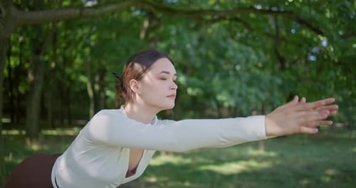 Young Beautiful Athletic Woman in Sportswear Doing Stretching and Warming Up in the Park Near a Tree