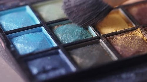 Makeup Brush Touches Eyeshadow in Colorful Palette
