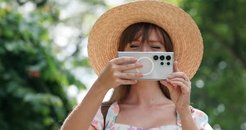 Woman Holding Phone Up To Her Face Outside