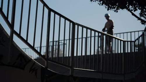 Skateboarder Performing Stunts at Skate Park on Sunny Day