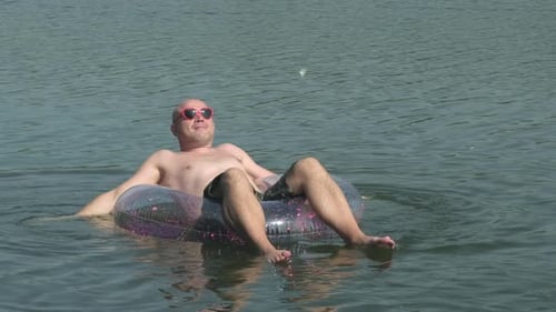 Happy Funny Man Wearing Heart Shaped Sunglasses Floating on Swimming Lap