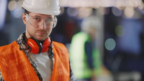 Construction Worker Examining Blueprints at Urban Construction Site