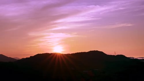 Paysage du lever du soleil au sommet de la montagne, avec des nuages colorés dans le ciel.