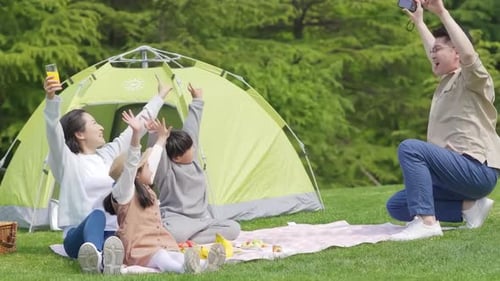 Happy family in the outdoor outing having a picnic in the park