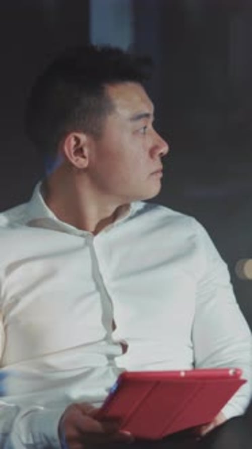 Man Using Tablet Device Indoors During a Meeting