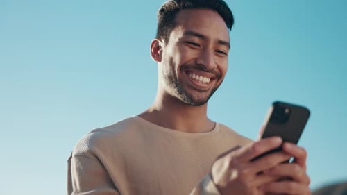 Happy Young Man Using Phone Outdoors