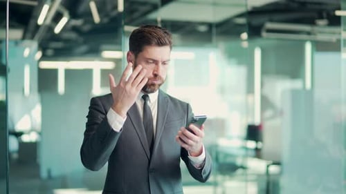 young angry annoyed and displeased business man in office using smart mobile phone failure. Cannot