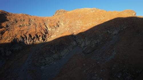 Golden hour mountain landscape with rugged terrain and striking autumn hues