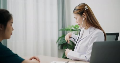 Caring Doctor Examines Patient with Stethoscope in Office