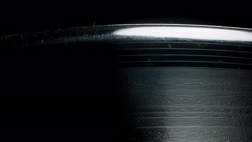 Macro view of the spiral sound track groove on a vinyl record. Zooming in.