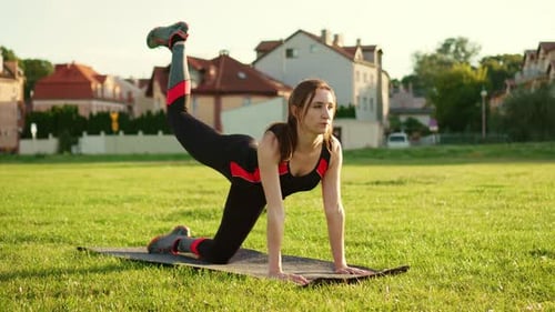 Joven y hermosa mujer caucásica que se estira y se calienta para hacer ejercicio entrena los músculos de sus piernas