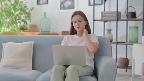Woman Massaging Sore Neck While Working on Laptop