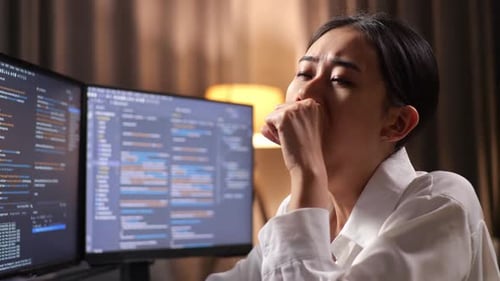 Primer plano de una programadora bostezando mientras crea una innovadora aplicación de desarrollo de ingeniera de software