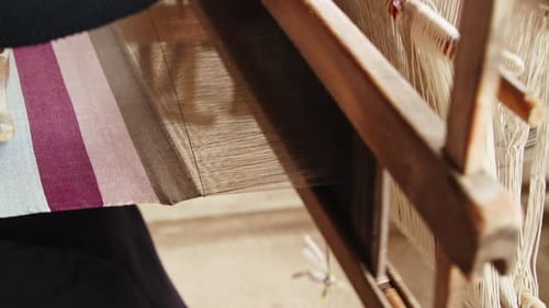Crafting intricate textiles in a traditional looms workshop in a serene setting
