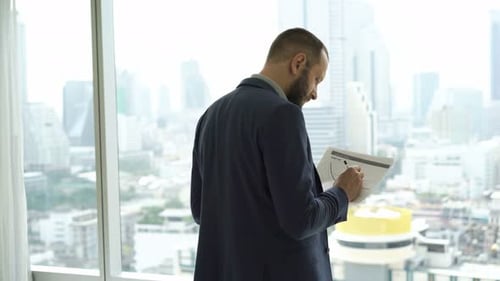 Man reviews documents in modern city office