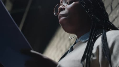 Young Woman Reading Script Against Brick Wall
