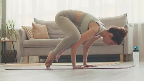 Woman Performs Yoga Pose on Mat in Home