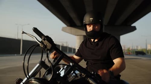 Um motociclista usa óculos escuros no fundo de um estacionamento. Hobbies como o motociclismo na modernidade