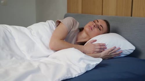 Woman Sleeping Peacefully in Bed at Home