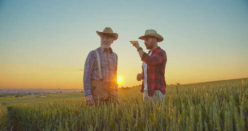 Smart Agritech Livestock Farming Two Adult Caucasian Smiling Men Wearing Hat Standing at the Green