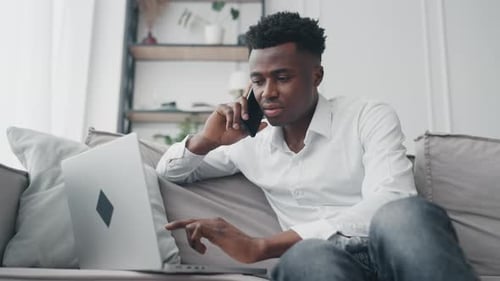 Young Adult Working and Talking on Phone at Home