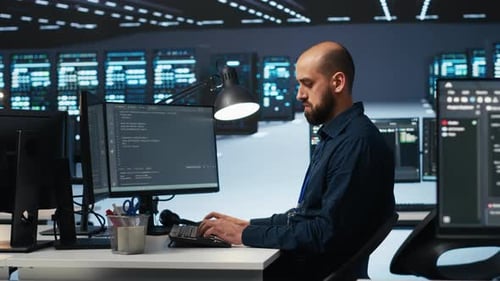 Technician Typing Code on Computer to Mend Data Center Racks