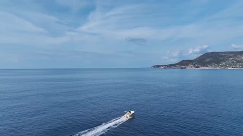 Aerial Video of a Speedboat Moving Across the Ocean With White Waves Behind It As It Approaches the